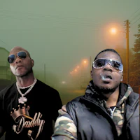 two men in sunglasses standing next to each other on a street